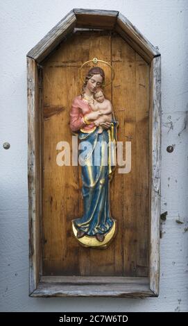Vertikale Aufnahme einer religiösen Skulptur auf einem hölzernen Brett Stockfoto
