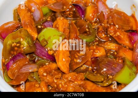 Honig-Chilipartoffeln in einer würzigen Sauce, Sesam und grüne Zwiebeln in der Nähe, beliebte indisch-chinesische Küche. Selektiver Fokus Stockfoto