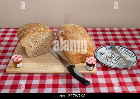 Frisch gebackenes Brot mit Sesamsamen auf einem Holzbrettchen Stockfoto