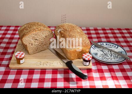 Frisch gebackenes Brot mit Sesamsamen auf einem Holzbrettchen Stockfoto