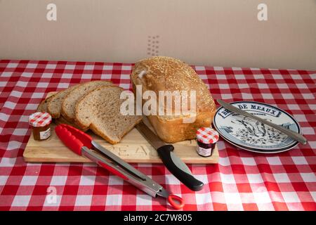 Scheiben frisch gebackenes Brot mit Sesamsamen auf einem hölzernen Brotbrett Stockfoto