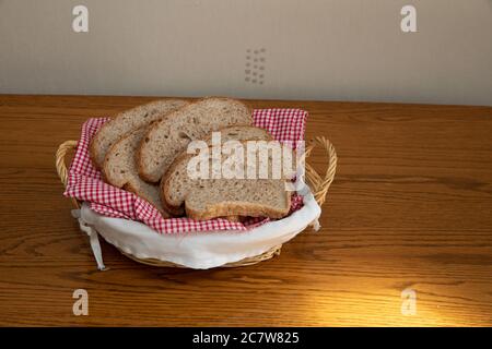 Scheiben frisch gebackenes braunes Brot mit Sesamsamen in einem Weidenkorb Stockfoto