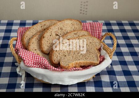 Scheiben frisch gebackenes braunes Brot mit Sesamsamen in einem Weidenkorb Stockfoto