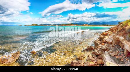 Die Bucht von Nora und der Strand, die mittelalterliche Kirche Sant'Efisio in der Nähe des Ufers und die Berge im Hintergrund. Ort: Nora, Pula, Sardinien, Italien Europa Stockfoto