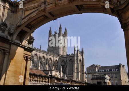 Bath Abbey, durch den kunstvollen Bogen auf der York Street gesehen. Ein Teil der römischen Bäder sind am unteren Bildrende zu sehen.Bad. Somerset. GROSSBRITANNIEN Stockfoto