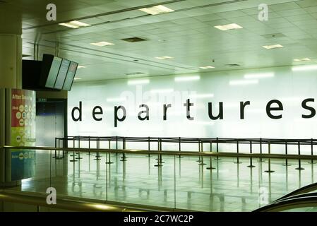 Das Innere des Flughafenterminals zeigt ein Abflugschild, leere Warteschlangen und Informationsbildschirme. Flughafen Glasgow Stockfoto