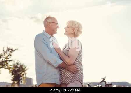 Der ältere Mann liebt seine Frau, die sie umarmt Stockfoto