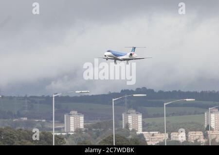 Kommerzielles Flugzeug, das sich der Stadt nähert, um an einem bewölkten Tag zu landen Stockfoto