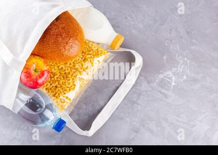 Lebensmittelspenden in Leinenbeutel. Lieferung von Lebensmitteln in Öko-Beutel. Öko-Tasche mit Lebensmitteln liefert Vorrat. Draufsicht. Speicherplatz kopieren Stockfoto