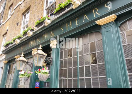 Laternen, Beschilderung und hängende Körbe außerhalb der Hand und Scheren öffentlichen Haus auf der Middle Street, Smithfield, London, EC1, Großbritannien Stockfoto