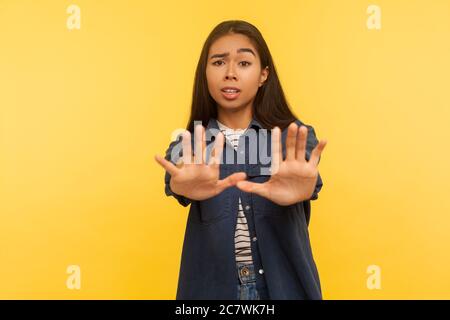 Nein, ich fürchte! Portrait von Angst Mädchen in Denim-Shirt stehen mit erhobenen Händen Stop-Geste, Panik suchen Angst vor Gefahr, Phobie. Indoor Stockfoto