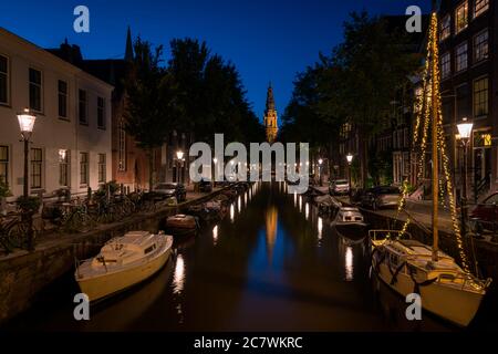 Spiegelung der Lichter der Stadt auf dem Kanal bei Nacht in Amsterdam, Niederlande. Stockfoto