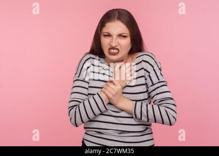 Handschäden, Verletzungen. Portrait der Frau im gestreiften Sweatshirt reiben Wunden Arm, Stirnrunzeln und leiden an schmerzhaften verstauchten Handgelenk, rheumatoide Arthriti Stockfoto