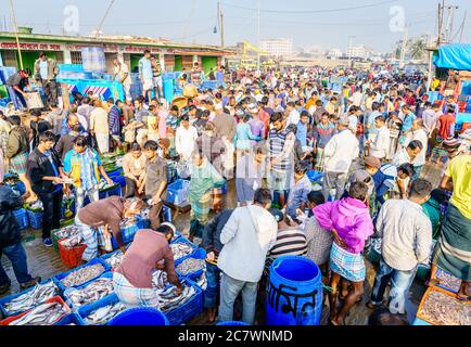 Chittagong, Bangladesch, 23. Dezember 2017: Händler, die Fisch auf dem überfüllten Markt in der Nähe des Karnaphuli Flusses in Chittagong sortieren Stockfoto