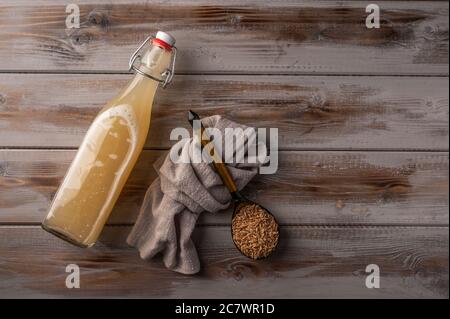 Draufsicht hausgemachte tradishional russischen hellen Roggen Kvass in Flasche und Leinen Serviette auf Holzhintergrund. Wunderbar gesundes Erfrischungsgetränk für den Sommer Stockfoto