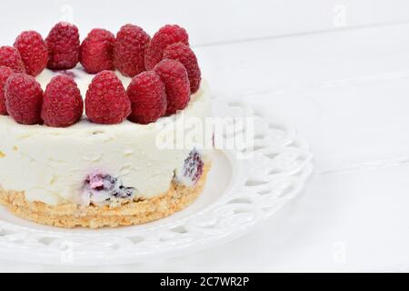 Mini Käsekuchen mit weißer Schokolade und Himbeeren auf Holztisch Stockfoto