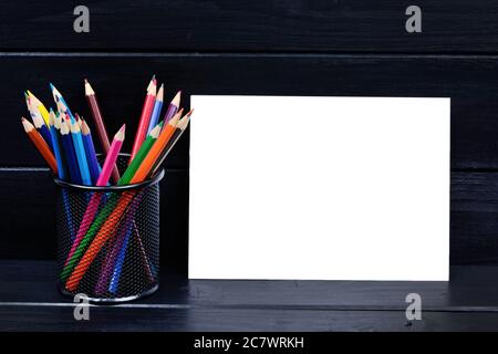 Leeres Papier mit bunten Stiften auf schwarzem Holztisch Stockfoto