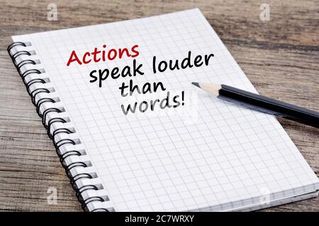 Taten sprechen mehr als Worte! Text auf Notizbuch auf einem Holztisch Stockfoto