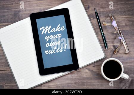 Machen Sie Ihre eigenen Regeln! Text auf Tablet-Gerät auf einem Holztisch Nahaufnahme Stockfoto