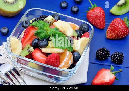 Salat mit frischem Obst und Beeren in einer Schüssel auf dem Tisch Stockfoto