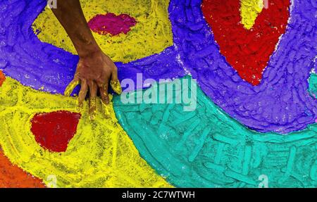 High-Angle-Aufnahme einer Person Hand Malerei den Boden Mit Kreide in Nepal Stockfoto