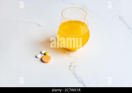 Nahaufnahme von Multivitamin und Brausetabletten mit dem Glas Saft Stockfoto