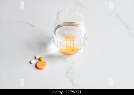 Nahaufnahme von Multivitamin und Brausetabletten mit dem Glas Von Wasser Stockfoto