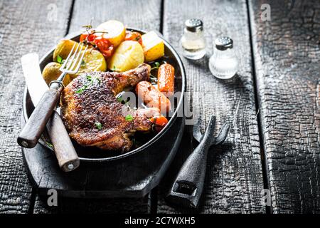 Gegrilltes Hühnerbein mit Kräutern auf Metallplatte Stockfoto