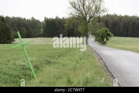 Grünes Kreuz auf der Seite der Straße Stockfoto