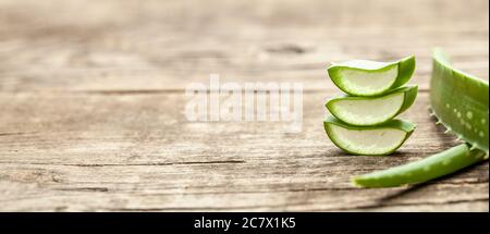 Stücke Aloe Vera mit Fruchtfleisch auf einem hölzernen Hintergrund. Stockfoto