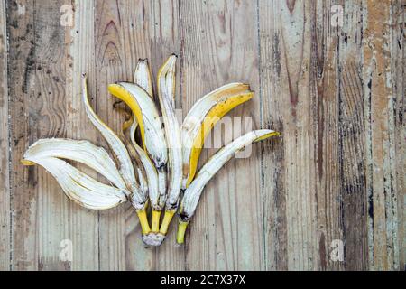 Bananenschale auf einem alten Holzhintergrund. Konzept der organischen Müllsortierung Stockfoto