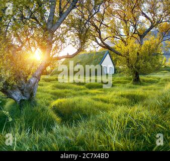 Malerische Aussicht auf Rasen-Top-Kirche Hofskirkja während des Sonnenuntergangs. Lage: Dorf Hof, Skaftafell, Vatnajokull Nationalpark, Europa. Stockfoto