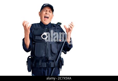 Senior stattlichen Mann trägt Polizei Uniform verrückt und verrückt schreien und schreien mit aggressivem Ausdruck und Arme angehoben. Frustration Konzept. Stockfoto