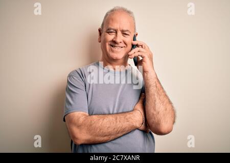 Mittelalter Hortmann mit Gespräch auf dem Smartphone sprechen über weißem Hintergrund mit einem glücklichen Gesicht stehen und lächeln mit einem selbstbewussten Lächeln Stockfoto
