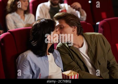 Portrait von romantischen jungen Paar küssen im Kino, während genießen romantische Datum, kopieren Raum Stockfoto