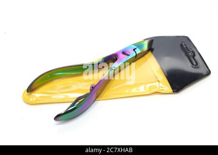 Nahaufnahme einer bunten Schere auf einem gelben Paket isoliert Auf weißem Hintergrund Stockfoto