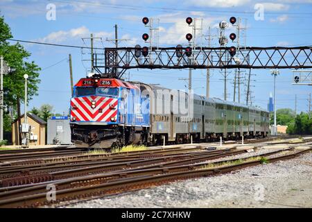 Franklin Park, Illinois, USA. Ein Metra-Pendlerzug, der unter einem Signalturm kurz vor der Ankunft am Franklin Park-Pendlerbahnhof vorbeifährt. Stockfoto