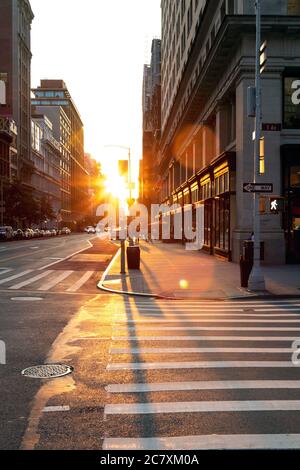 Das Licht des Sonnenuntergangs leuchtet auf einem leeren Fußgängerüberweg an der Kreuzung der 23rd Street und 5th Avenue in Manhattan, New York City NYC Stockfoto