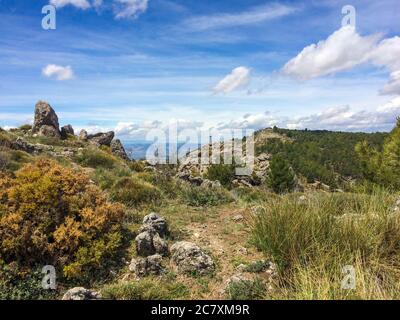 Hohe Berge bedeckt mit Grün und schimmern unter der Bewölkung Blauer Himmel Stockfoto