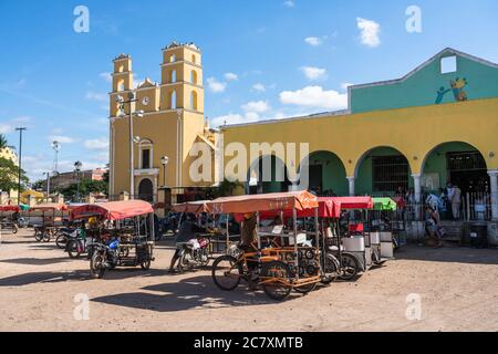 Mototaxis warten auf Geschäfte vor der kolonialen Kirche Nuestra Senora de la Natividad aus dem 16. Jahrhundert oder unserer Lieben Frau von der Geburt Christi und dem Markt Stockfoto