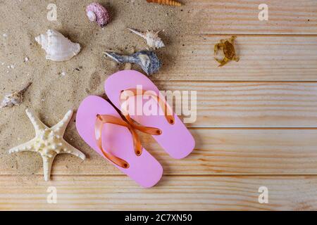 Reiseurlaub während mit Muscheln, Seesterne, auf Flip Flops die gegen Ruhe am Strand entspannend Stockfoto