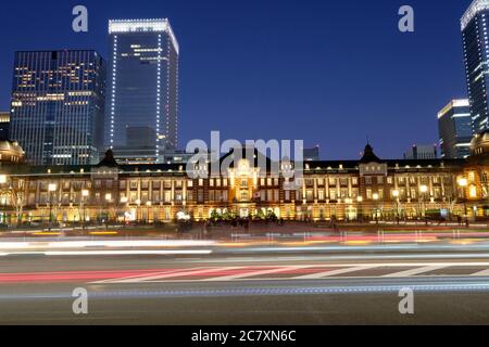 Autos, die am berühmten Bahnhof in Tokio bei Nacht vorbeifahren. Lange Belichtung Stockfoto