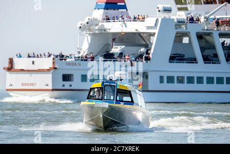 Norderney, Deutschland. Juli 2020. Die Schnellfähre Inselexpress der Reederei Norden-Friesland fährt auf der Nordsee im Wattenmeer vor der Fähre Friesia IV. Zwei kleine Schnellboote für jeweils maximal elf Passagiere werden künftig nach Juist fahren. Aufgrund ihres niedrigen Tiefgangs können die Schnellfähren Passagiere auch bei niedrigeren Wasserständen als die großen Fähren umleiten. Quelle: Hauke-Christian Dittrich/dpa/Alamy Live News Stockfoto