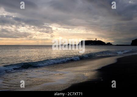 Schöner Sonnenuntergang von Enoshima Insel in Kanagawa Japan. Meereswellen gegen Strand. Stockfoto