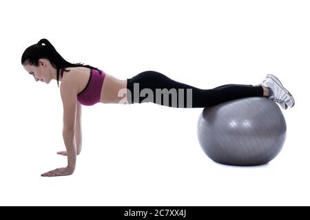 Silhouette der schlanken Frau in Sport tragen tun Push-up-Übungen auf Fitness-Ball isoliert auf weißem Hintergrund Stockfoto