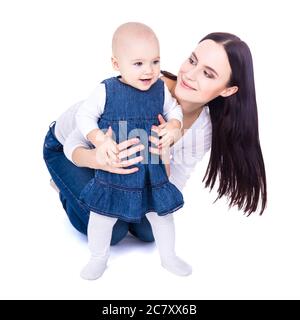 Erster Schritt Konzept - glücklich junge Mutter spielt mit Baby Mädchen isoliert auf weißem Hintergrund Stockfoto