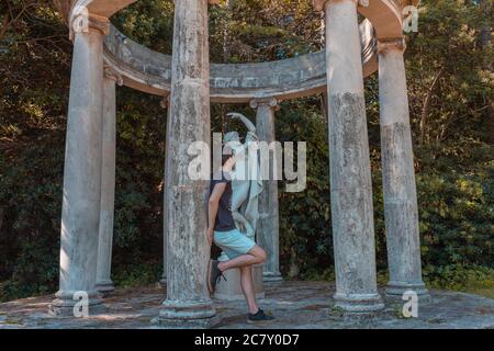 Mann, der sich auf die Säulen im Jardins de Joan Maragall in Barcelona, Spanien lehnt Stockfoto