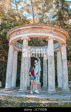 Frau, die sich auf die Säulen im Jardins de Joan Maragall in Barcelona, Spanien lehnt Stockfoto