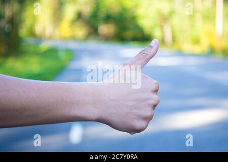 Nahaufnahme der männlichen Hand, die auf der Waldstraße anhält Stockfoto