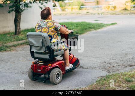 Poltava, Ukraine - Juli 2020 Ältere Frau auf e-mobile Fahrzeug für behinderte Person Stockfoto